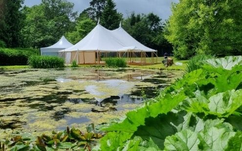 Beautfil image of our 12x18m Celeste Pole Marqee with no sides and a small catering tent