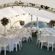 Capri Marquee internal image with round banquet tables and ivy archways