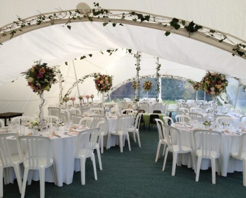 Capri Marquee internal image with round banquet tables and ivy archways